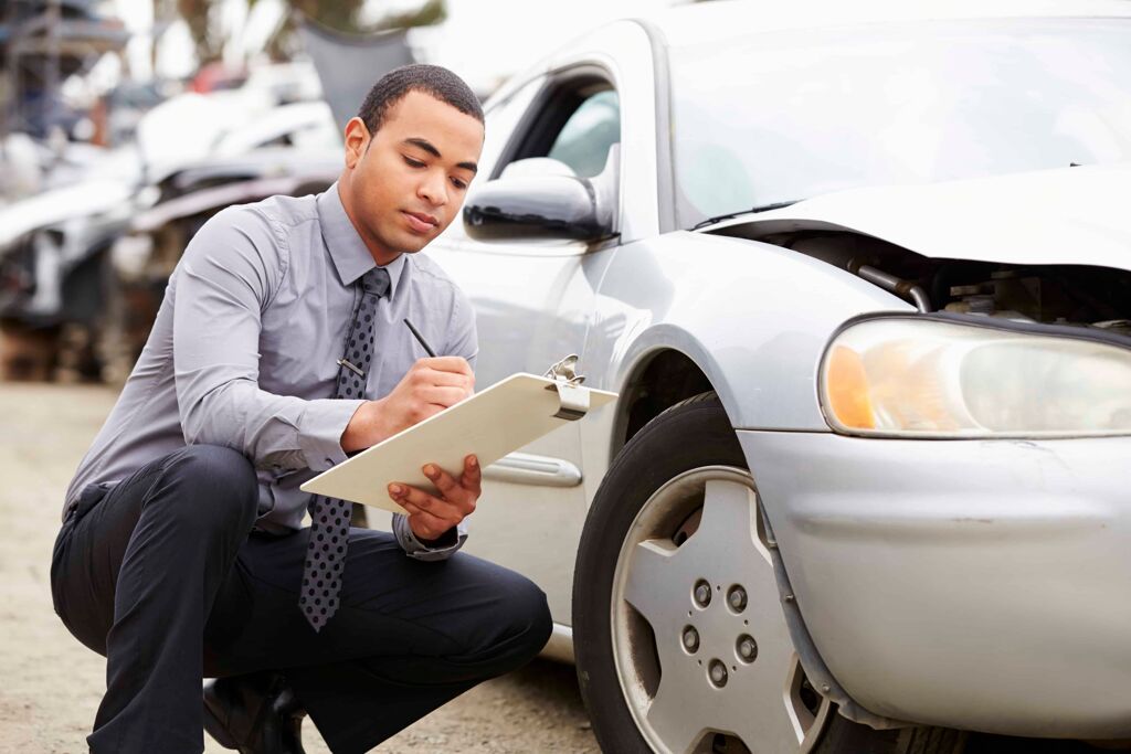 loss adjuster inspecting car involved in accident PF3X2KQ